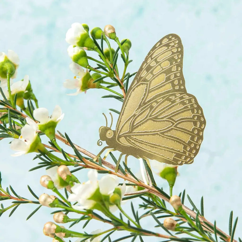 Schmetterling aus Metall Gold auf Pflanze
