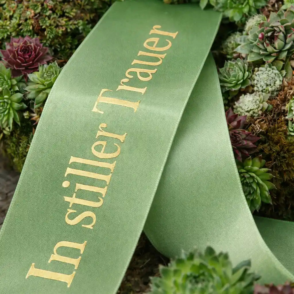 Sukkulentenkranz mit grüner Trauerschleife zur Beerdigung